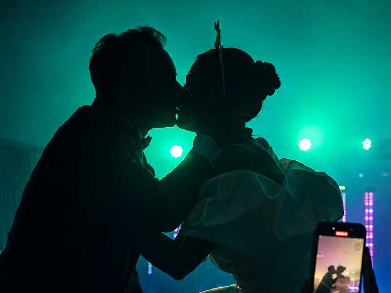 Los novios bailando bajo la iluminación de color de la fiesta de su boda