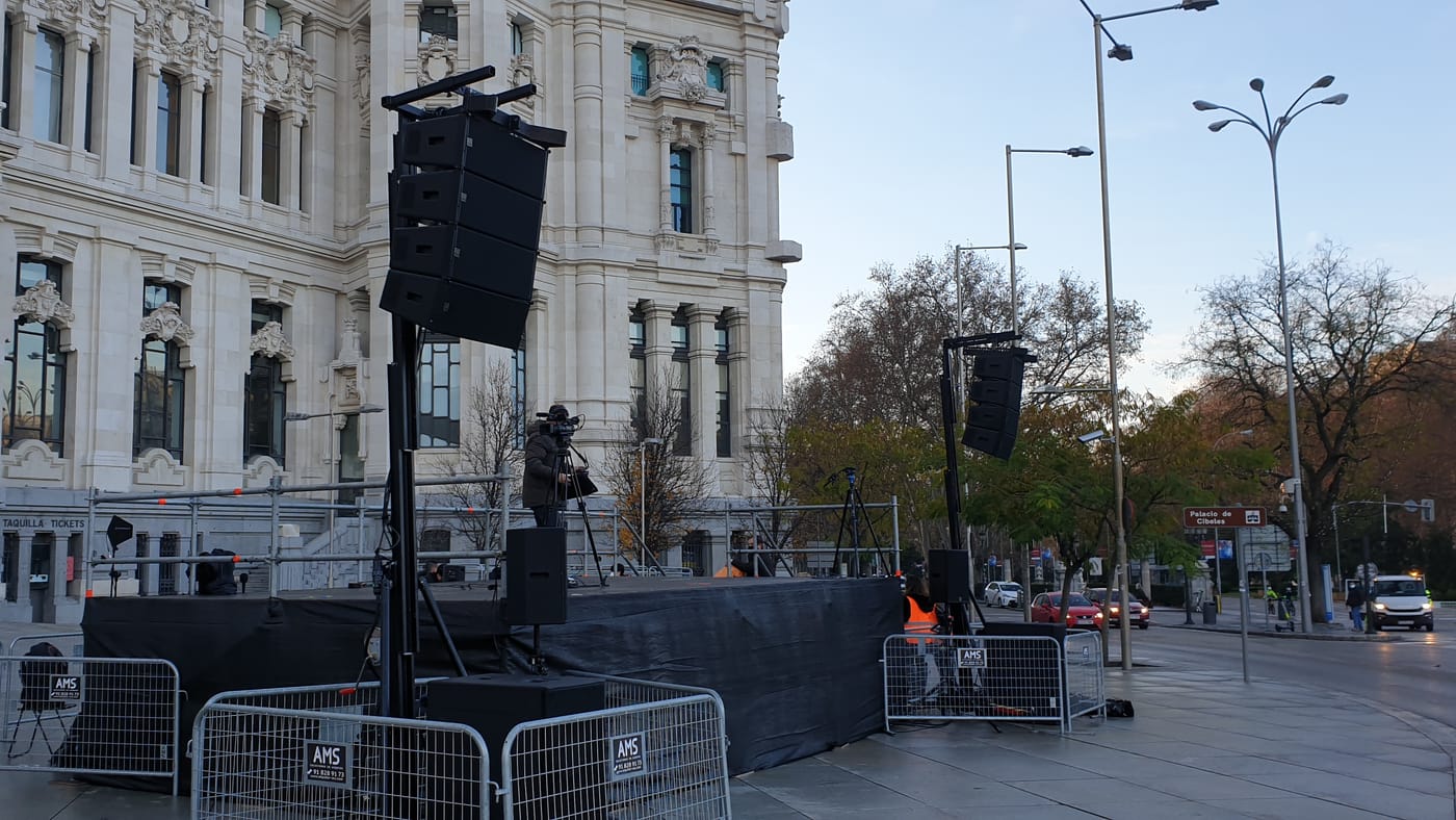 Dos torres con line array elevadas a ambos lados de un escenario montado en la calle, en Madrid
